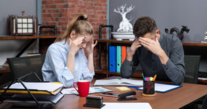 front view tired young female worker her male co worker sitting table office enviroment